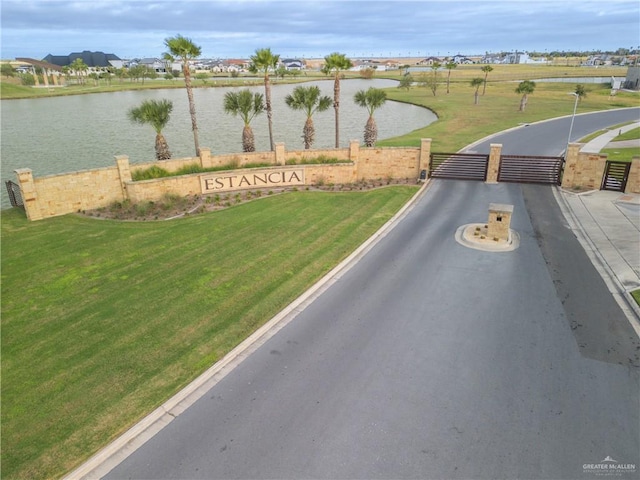 view of street with a water view and a gated entry