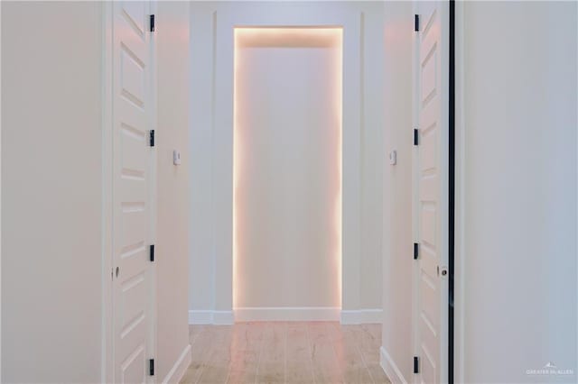 hallway with light wood-style flooring and baseboards