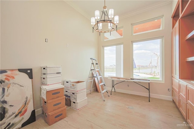 interior space with light wood-style floors, baseboards, ornamental molding, and a notable chandelier