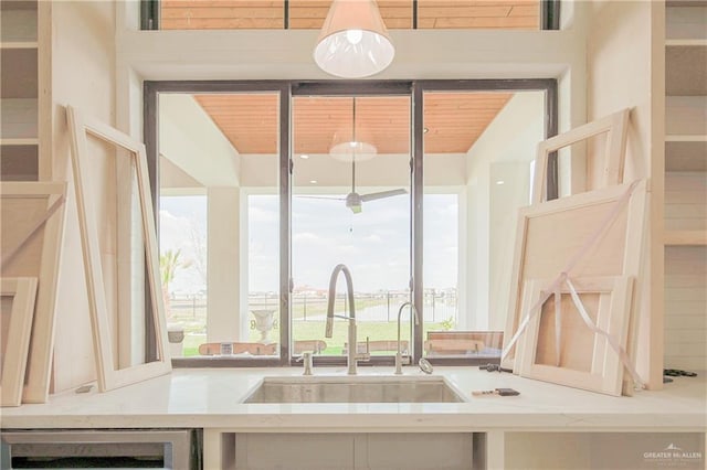 kitchen with beverage cooler, wooden ceiling, and a sink