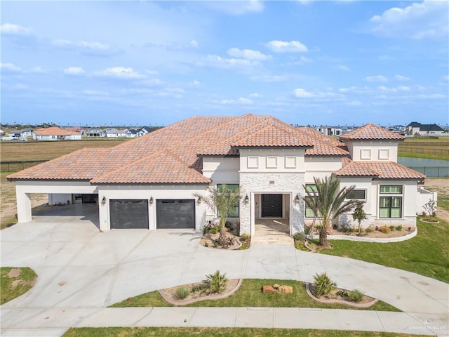 mediterranean / spanish house with a garage, a tile roof, concrete driveway, stone siding, and stucco siding