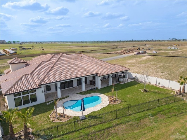 view of pool featuring a rural view, a fenced backyard, a yard, and a patio