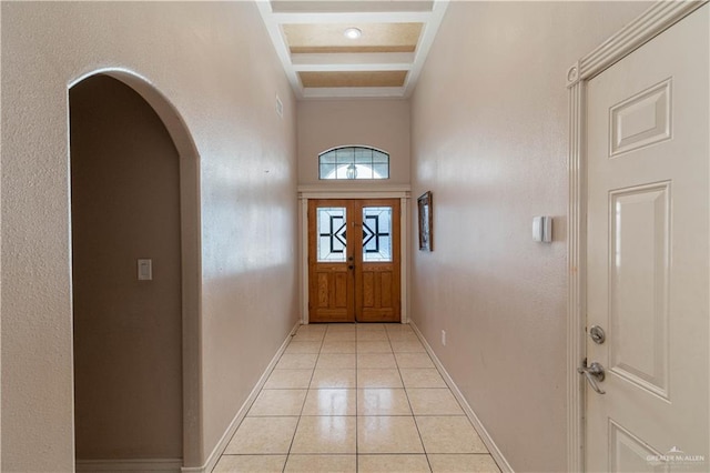 entryway featuring beamed ceiling, light tile patterned floors, and coffered ceiling