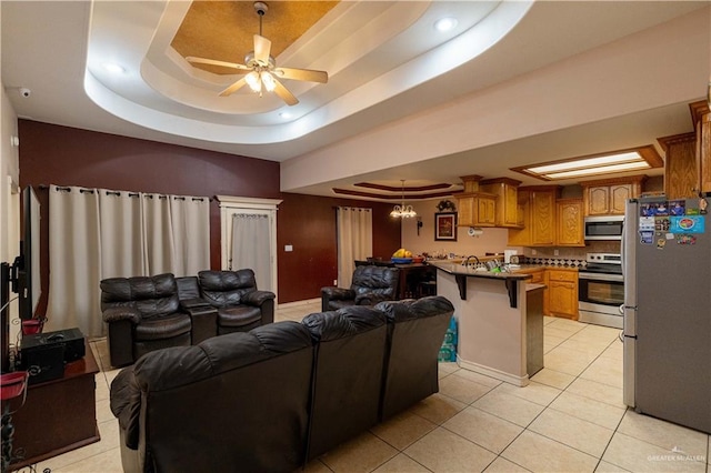 living room featuring light tile patterned floors, a raised ceiling, and ceiling fan