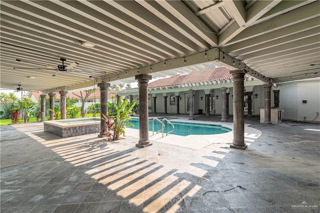 view of swimming pool with ceiling fan, a patio area, and an in ground hot tub