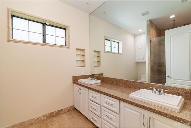 bathroom featuring tile patterned flooring, vanity, toilet, and a shower with shower door