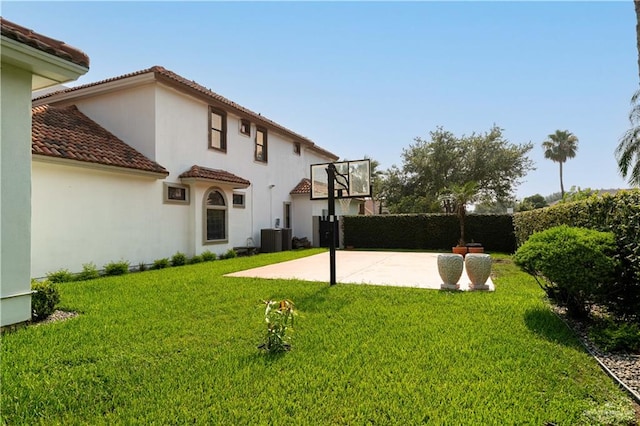 rear view of property featuring a yard, a patio, and central air condition unit