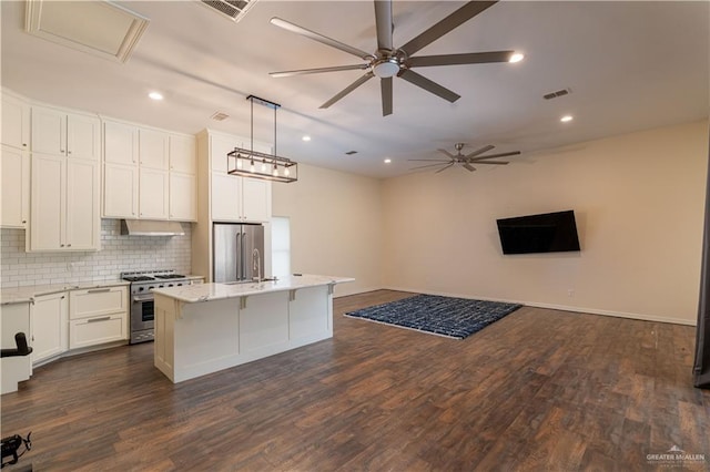 kitchen featuring a center island with sink, decorative light fixtures, dark hardwood / wood-style floors, and stainless steel appliances