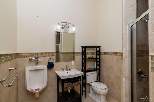 bathroom with sink, tile patterned flooring, toilet, a shower with shower door, and tile walls