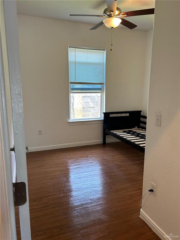 spare room with ceiling fan and dark wood-type flooring