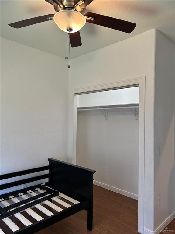 bedroom with ceiling fan, a closet, and dark wood-type flooring