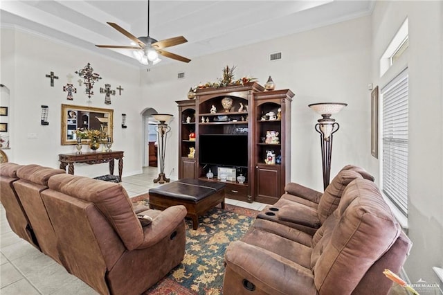 living room featuring ceiling fan, arched walkways, a towering ceiling, visible vents, and tile patterned floors