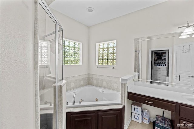 bathroom featuring a whirlpool tub, tile patterned floors, a stall shower, and vanity
