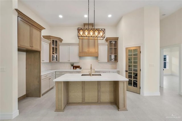 4012 Burr Dr, Edinburg, TX 78542 - kitchen with light countertops, an island with sink, glass insert cabinets, pendant lighting, and recessed lighting