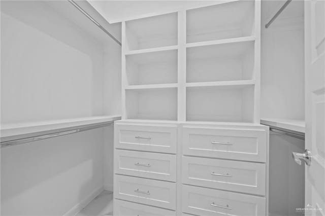 walk in closet featuring marble finish floor
