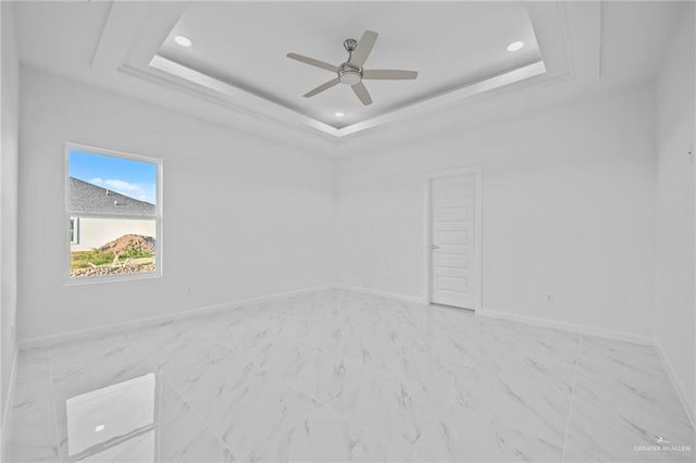 empty room with a tray ceiling, baseboards, and recessed lighting