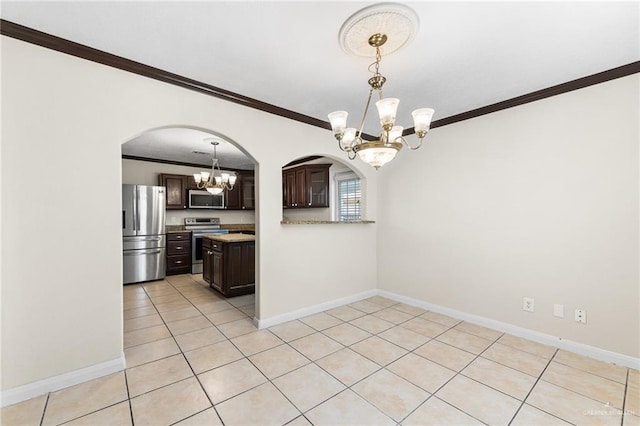 8907 Other, San Antonio, TX 78242 - kitchen featuring appliances with stainless steel finishes, a chandelier, ornamental molding, dark brown cabinets, and arched walkways