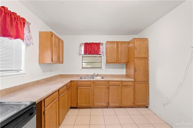 kitchen featuring stove, sink, and light tile patterned floors
