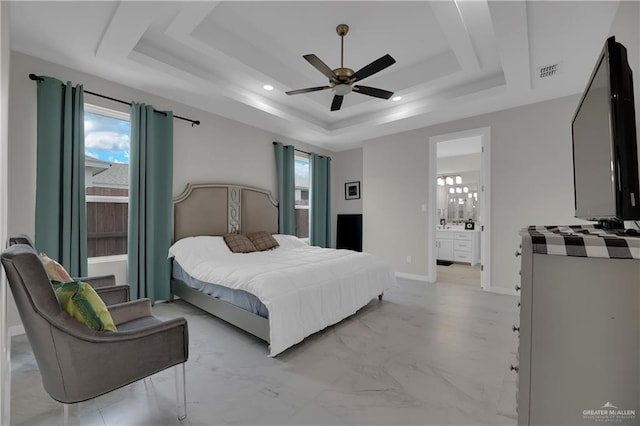 bedroom with ceiling fan, multiple windows, connected bathroom, and a tray ceiling