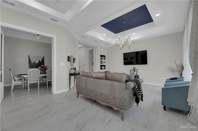 living room with an inviting chandelier and a tray ceiling