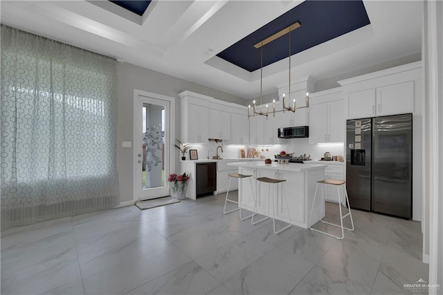 kitchen featuring white cabinets, a raised ceiling, and appliances with stainless steel finishes