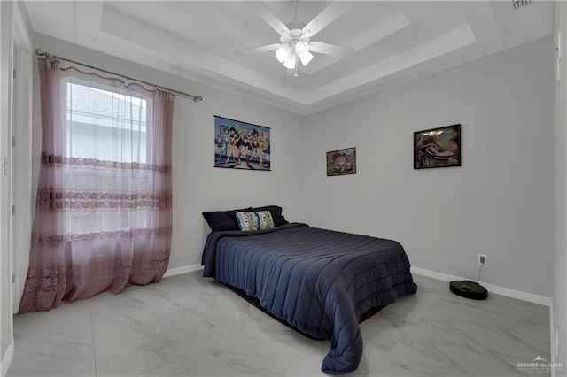 bedroom with a raised ceiling and ceiling fan