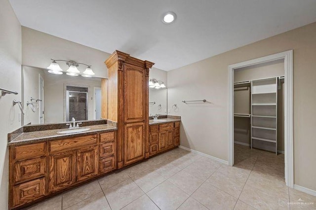 bathroom featuring vanity, a shower with shower door, and tile patterned flooring