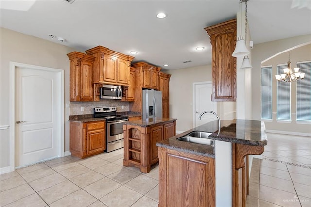 kitchen featuring appliances with stainless steel finishes, sink, a center island, light tile patterned floors, and kitchen peninsula