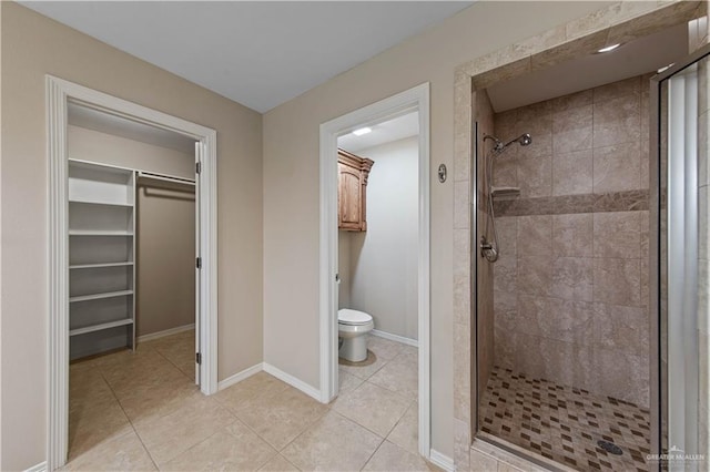 bathroom featuring a shower with shower door, tile patterned floors, and toilet