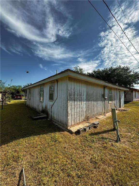 view of side of home with a lawn