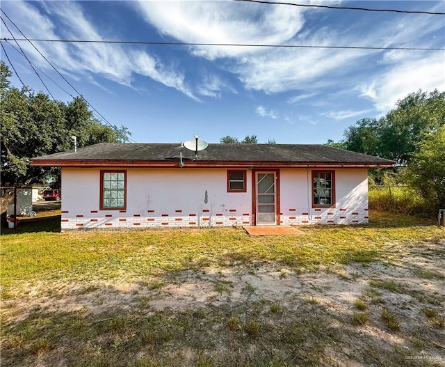 rear view of property featuring a lawn