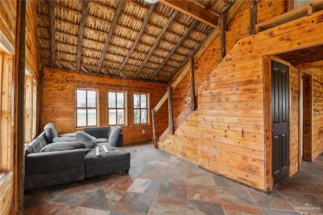 living room with lofted ceiling and wooden walls