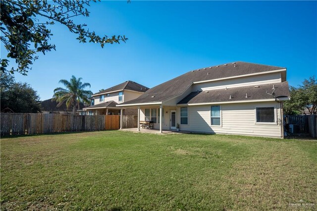 rear view of property with a lawn and a patio area