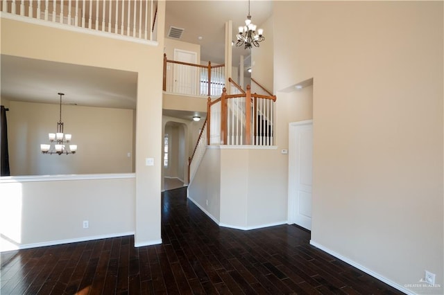 interior space with a chandelier, dark hardwood / wood-style floors, and a high ceiling