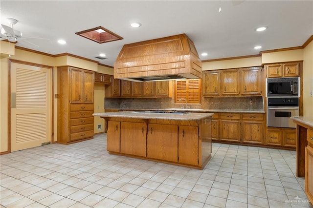 kitchen featuring black microwave, a kitchen island, oven, and premium range hood