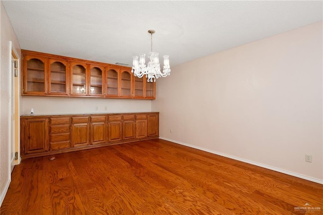 interior space with hanging light fixtures, a notable chandelier, and dark hardwood / wood-style flooring