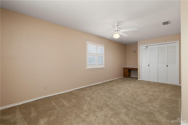 unfurnished bedroom with light carpet, ceiling fan, and a closet