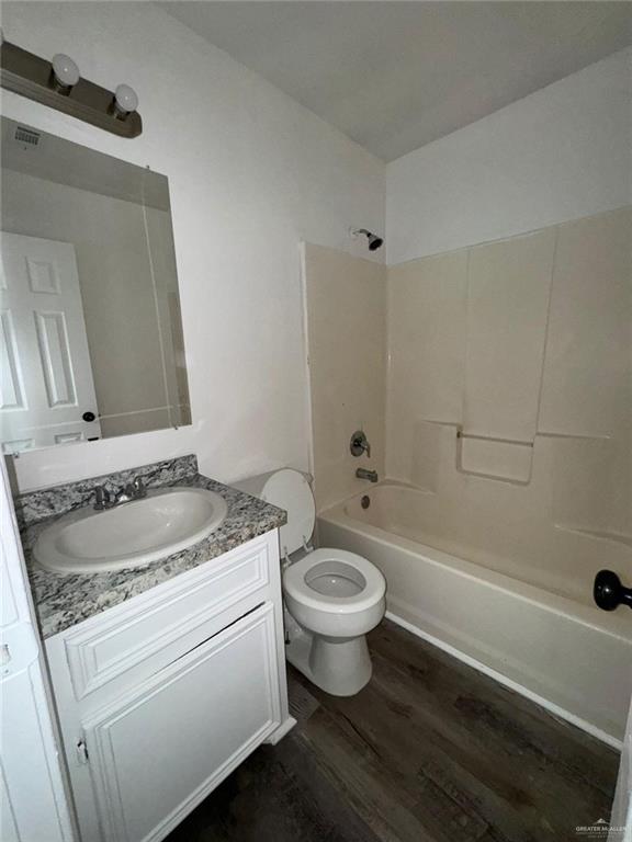 full bathroom with vanity, wood-type flooring, bathtub / shower combination, and toilet