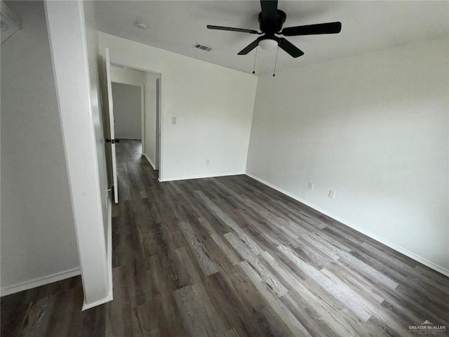 empty room with ceiling fan and dark hardwood / wood-style flooring