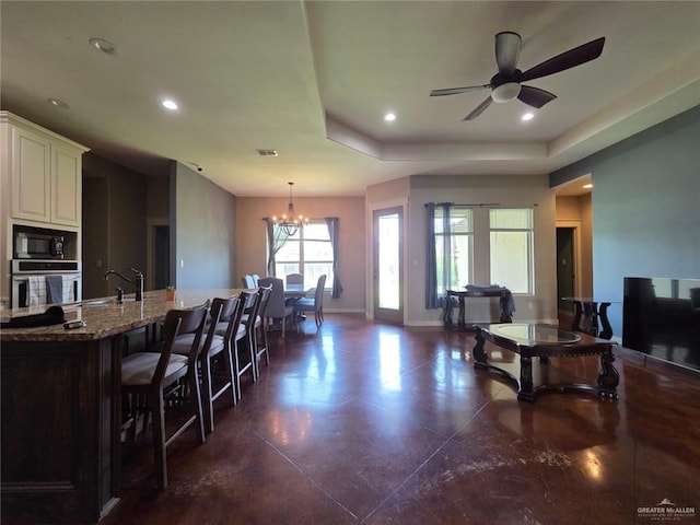 16637 W Barnes Ct, Harlingen, TX 78552 - kitchen with stainless steel oven, black microwave, light stone counters, a chandelier, and a sink