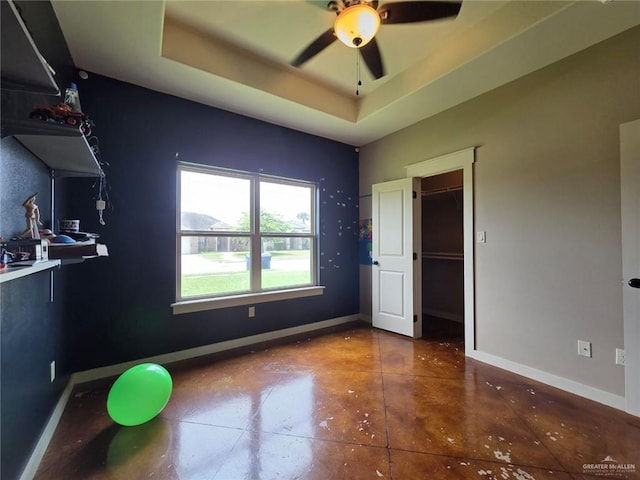 16637 W Barnes Ct, Harlingen, TX 78552 - unfurnished bedroom with a raised ceiling, baseboards, finished concrete flooring, and ceiling fan