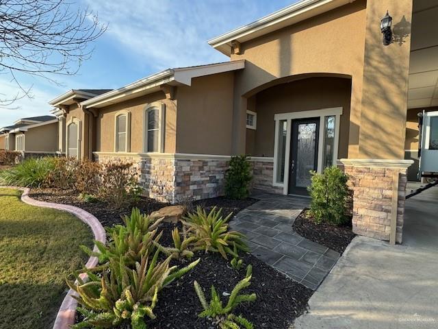 property entrance featuring a lawn