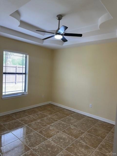 1502 W Kennedy Ave, Alton, TX 78573 - spare room with a raised ceiling, ceiling fan, and baseboards