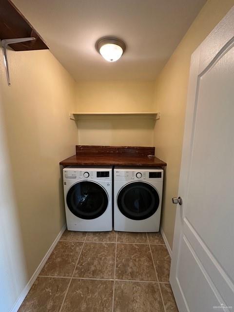 1502 W Kennedy Ave, Alton, TX 78573 - laundry room with washing machine and dryer, dark tile patterned flooring, and baseboards