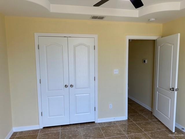 1502 W Kennedy Ave, Alton, TX 78573 - unfurnished bedroom with a closet, baseboards, dark tile patterned flooring, and ceiling fan