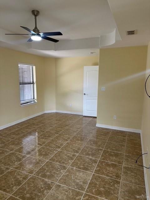 1502 W Kennedy Ave, Alton, TX 78573 - empty room featuring dark tile patterned flooring, baseboards, a ceiling fan, and a tray ceiling