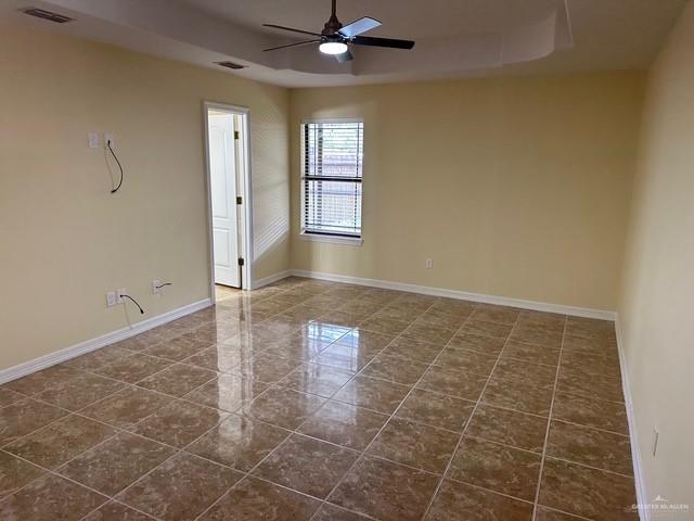 1502 W Kennedy Ave, Alton, TX 78573 - spare room featuring a raised ceiling, baseboards, and a ceiling fan