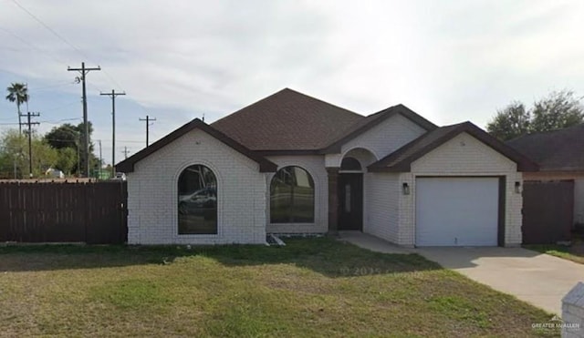 1502 W Kennedy Ave, Alton, TX 78573 - french country inspired facade with concrete driveway, an attached garage, and brick siding