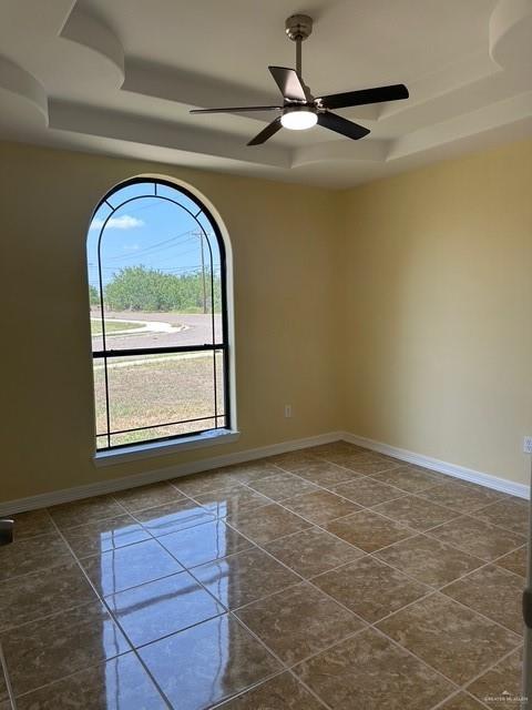 1502 W Kennedy Ave, Alton, TX 78573 - empty room with a tray ceiling and baseboards
