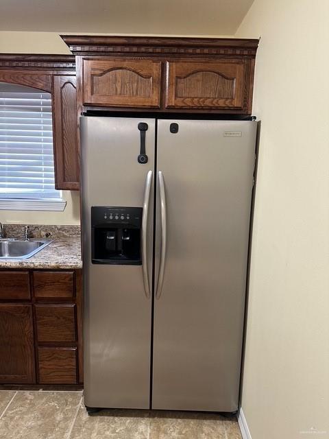 1502 W Kennedy Ave, Alton, TX 78573 - kitchen with stainless steel fridge with ice dispenser, a sink, dark brown cabinetry, and light stone finish flooring